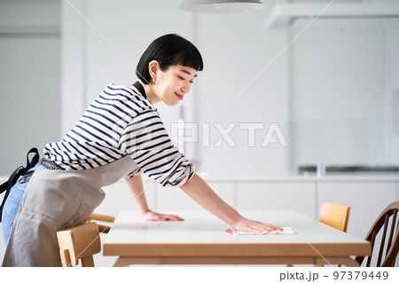 ダイニングテーブルを拭く若い女性 ダイニングテーブルを拭く若い女性 97379449