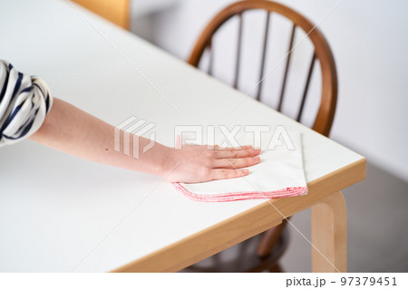 ダイニングテーブルを拭く若い女性 97379451