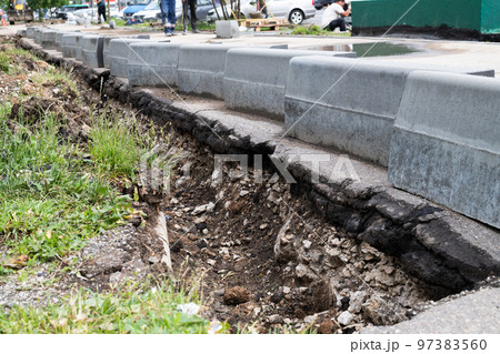 New curbs stand at the edge of the sidewalk. Preparing to repair road 97383560