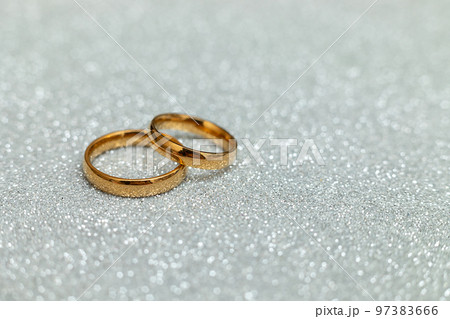 Will you marry me. Two golden wedding rings on silver glitter background. Engagement marriage proposal wedding concept. St. Valentine's Day postcard. Banner on valentines day. Copy space Will you marry me. Two golden wedding rings on silver glitter background. Engagement marriage proposal wedding concept. St. Valentine's Day postcard. Banner on valentines day. Copy space 97383666