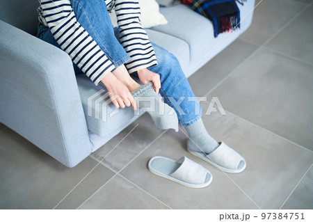 部屋で靴下を履く若い女性 部屋で靴下を履く若い女性 97384751