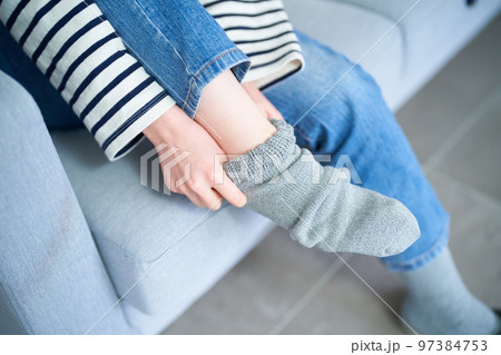 部屋で靴下を履く若い女性 97384753