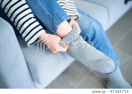 部屋で靴下を履く若い女性 97384754