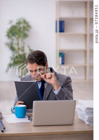Young male employee and too much work in the office 97384951