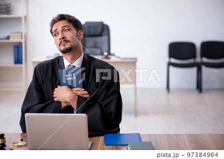Young male judge taking oath on holly bible 97384964