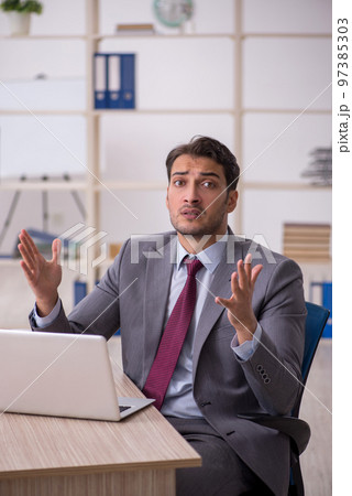 Young male employee working in the office 97385303
