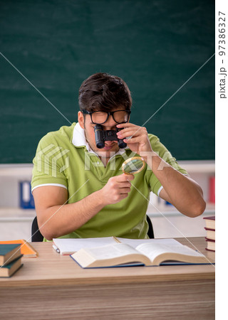Young male student sitting in the classroom 97386327