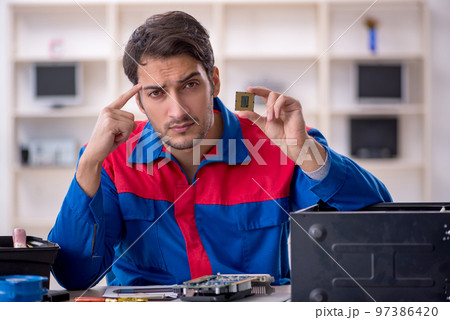 Young male repairman repairing computer Young male repairman repairing computer 97386420