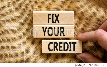 Fix your credit symbol. Concept words Fix your credit on wooden blocks on a beautiful canvas table canvas background. Businessman hand. Business, finacial and fix your credit concept. Copy space. Fix your credit symbol. Concept words Fix your credit on wooden blocks on a beautiful canvas table canvas background. Businessman hand. Business, finacial and fix your credit concept. Copy space. 97386957