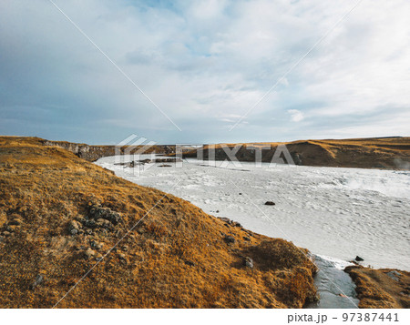 Grass covered hills and bright blue river Grass covered hills and bright blue river 97387441