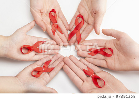 Health care and medicine concept. AIDS awareness. Many people hands are holding red awareness ribbons. International AIDS Day 97391258