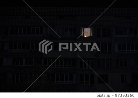 Light in one window in apartment multistorey building during the rolling blackout of electricity in a residential area of Kyiv after russian shelling. Light in one window in apartment multistorey building during the rolling blackout of electricity in a residential area of Kyiv after russian shelling. 97393260