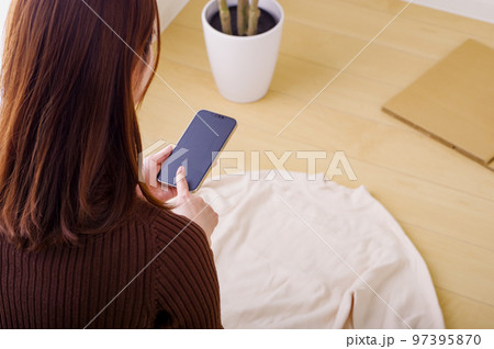 スマホでフリマ出品をする若い女性 スマホでフリマ出品をする若い女性 97395870