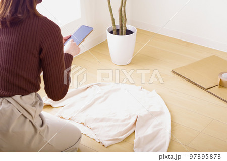 スマホでフリマ出品をする若い女性 スマホでフリマ出品をする若い女性 97395873