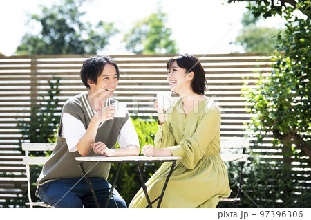 テラスでコーヒーを飲む若い夫婦 97396306