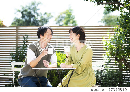 テラスでコーヒーを飲む若い夫婦 テラスでコーヒーを飲む若い夫婦 97396310