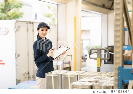 物流倉庫で働く若い女性の作業員 物流倉庫で働く若い女性の作業員 97402344