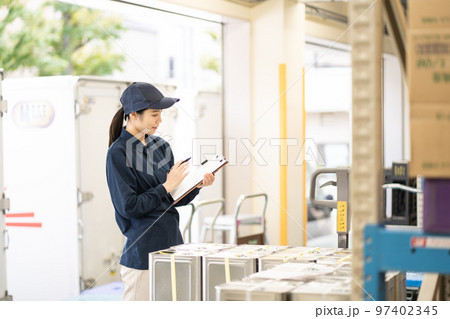 物流倉庫で働く若い女性の作業員 物流倉庫で働く若い女性の作業員 97402345