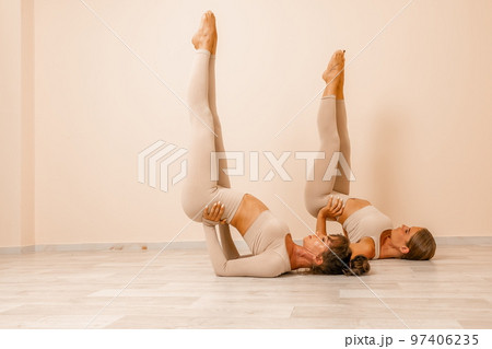 Well looking middle aged womans, fitness instructor in beige sportswear, preparing for stretching and pilates on yoga mat in the gym. Female fitness yoga concept. Healthy lifestyle harmony, meditation Well looking middle aged womans, fitness instructor in beige sportswear, preparing for stretching and pilates on yoga mat in the gym. Female fitness yoga concept. Healthy lifestyle harmony, meditation 97406235