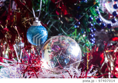 Close-up of Christmas decorations on a tree through lensball sphere Close-up of Christmas decorations on a tree through lensball sphere 97407014