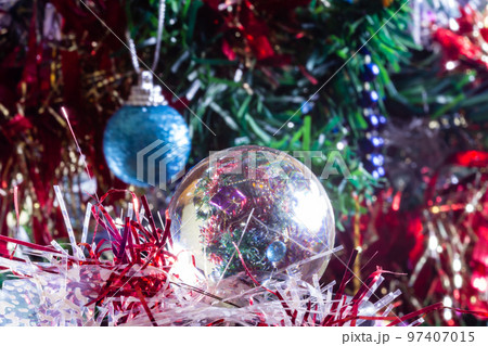 Close-up of Christmas decorations on a tree through lensball sphere Close-up of Christmas decorations on a tree through lensball sphere 97407015