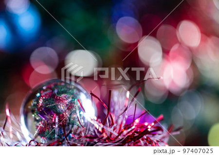Close-up of Christmas decorations on a tree through lensball sphere Close-up of Christmas decorations on a tree through lensball sphere 97407025