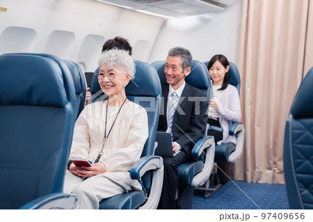 機内エンターテイメントを楽しむ高齢の女性 機内エンターテイメントを楽しむ高齢の女性 97409656