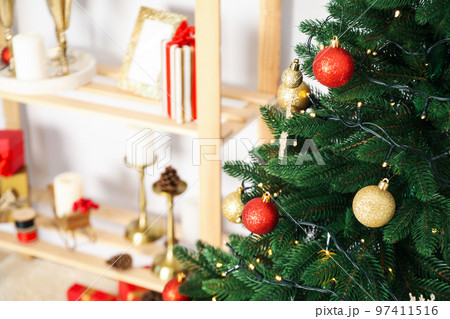 Christmas tree and shelving with Christmas accessories, space for text Christmas tree and shelving with Christmas accessories, space for text 97411516
