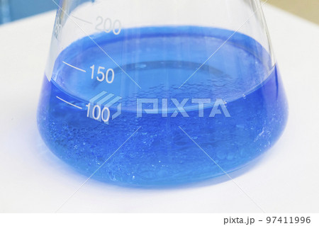 Blue liquid in a flask with sediment 97411996