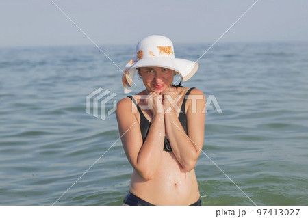 Woman in middle-aged hat in bikin at sea Woman in middle-aged hat in bikin at sea 97413027