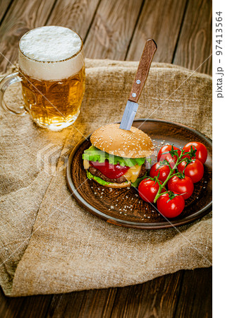 From above view of homemade burger on rustic wooden serving table with pint of beer. Selective focus 97413564