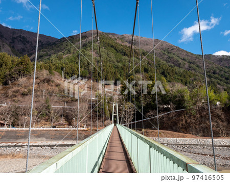 冬晴れの山梨県丹波山村の丹波川にかかるやまびこ橋 97416505