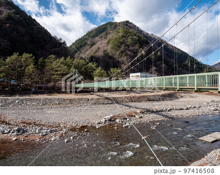 冬晴れの山梨県丹波山村の丹波川にかかるやまびこ橋 97416508