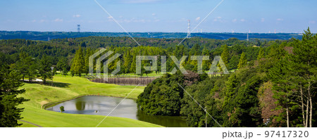 青空のゴルフ場・池や多数のコブがある打ち下ろしで難しいコースの眺めのパノラマ（千葉県木更津市） 97417320