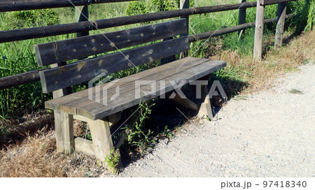 Old wooden bench in the park with inscriptions and cracks, a place to rest, a place to walk	 97418340