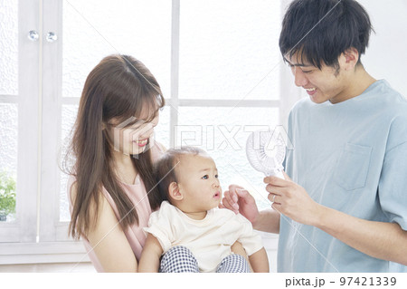 赤ちゃんにハンディファンを使う両親 97421339
