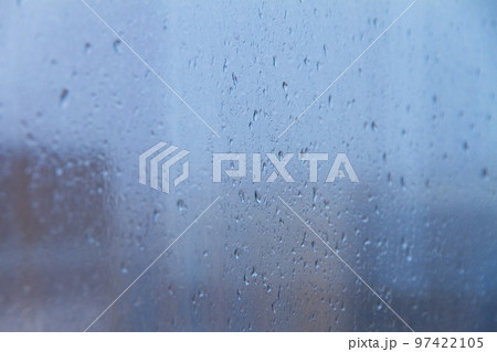 raindrops on blue glass window on cloudy day 97422105