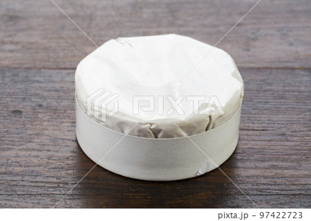Brie type of cheese. Camembert cheese on a wooden table packaged. Fresh Brie cheese. 97422723