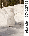 Funny snowman with scarf and hat in winter forest 97422731