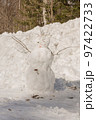 Funny snowman with scarf and hat in winter forest 97422733