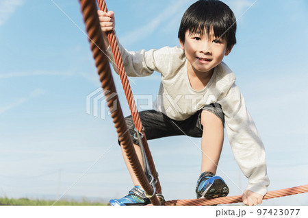 公園の遊具で遊ぶ5歳の男の子 97423077