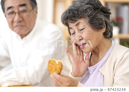 固い食べ物が食べづらいシニア女性 97423239