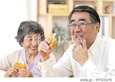 お煎餅を食べるシニア夫婦 97423245