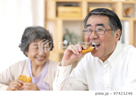 お煎餅を食べるシニア夫婦 97423246
