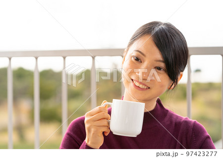 テラスでコーヒーを飲んで休憩している女性 テラスでコーヒーを飲んで休憩している女性 97423277