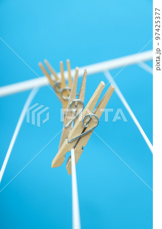 Clothespins hanging on drying rack on blue background 97425377