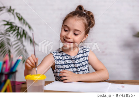 Inspired little girl at the table draw with paints 97428557