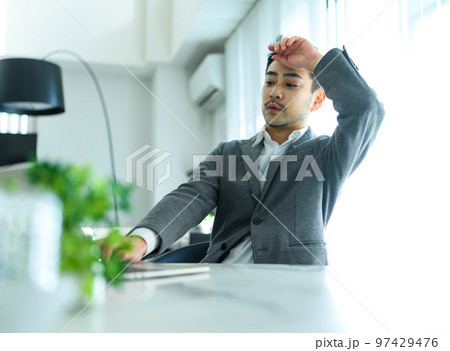 在宅ワーク中の30代の男性が疲れている 在宅ワーク中の30代の男性が疲れている 97429476