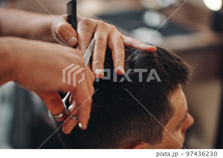 hairdresser does haircut for man in barber shop hairdresser does haircut for man in barber shop 97436230