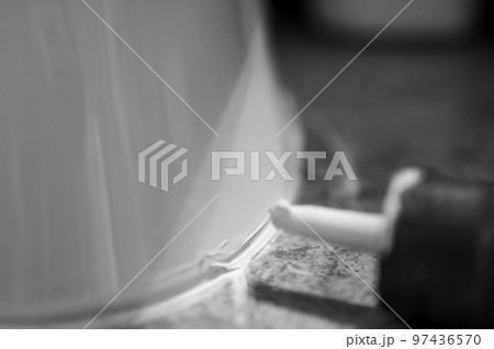 Selective focus on silicone caulking ready to be applied around the seal of a bathroom toilet. Selective focus on silicone caulking ready to be applied around the seal of a bathroom toilet. 97436570